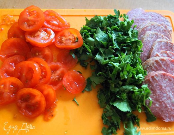 Нарезаем сервелат, помидорки и зелень
