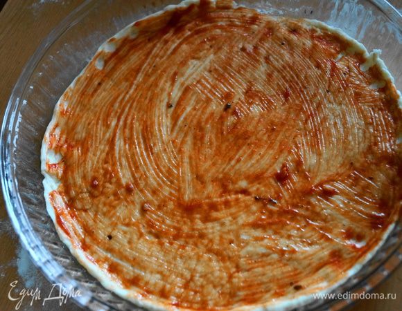 Выкладываем раскатанное тесто в форму для выпечки и смазываем томатной пастой (кетчупом)