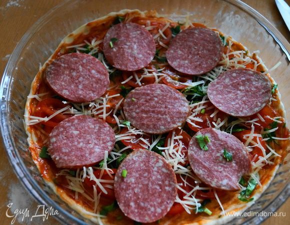 Посыпаем рубленной зеленью, выкладываем помидорки, каперсы (если есть) и сервелат, каждый слой пересыпаем небольшим количеством тертого сыра