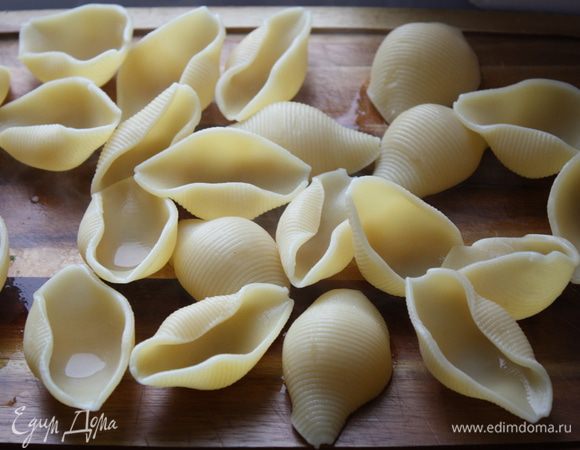 Тем временем ставим воду для пасты и в кипящей подсоленной воде отвариваем ракушки до полуготовности. Выкладываем их на ровную поверхность, так чтобы они не слипались.