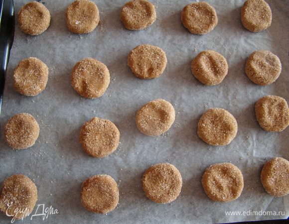 Скатываем шарики весом около 15-20 граммов каждый, обваливаем в сахаре, кладем на пергамент, немного приплюскивая