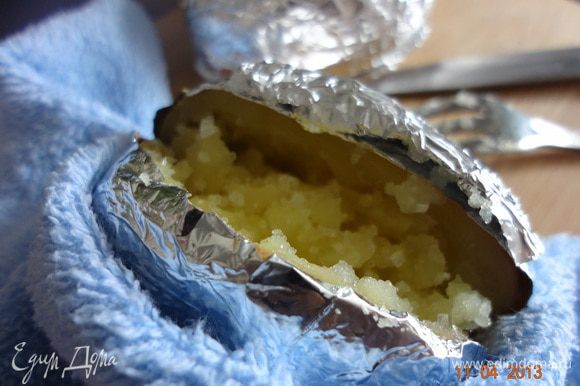 Нажать на картофелину, раскрывая надрез, вилкой перемешать мякоть, чуть присыпать морской солью.