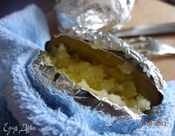 Нажать на картофелину, раскрывая надрез, вилкой перемешать мякоть, чуть присыпать морской солью.