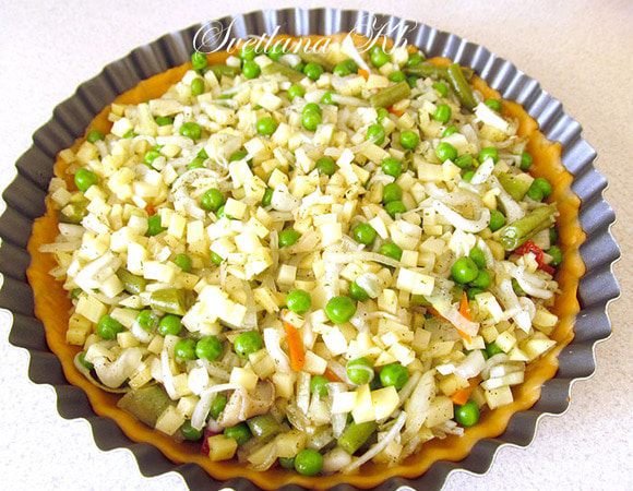 Тесто достаньте из холодильника и разрежьте на 2 неравные части. Большая часть будет дном, а меньшая - крышкой. Раскатайте тесто тонким пластом и распределите по форме. Я донышко всегда выстилаю пекарской бумагой.
Выложите  на тесто начинку.