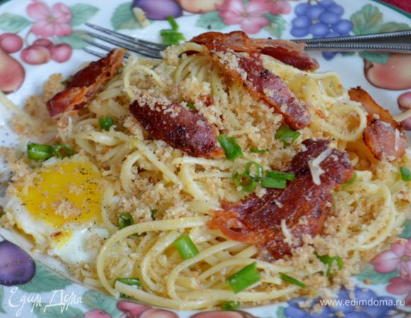 Разделить спагетти на 4 блюда.Также с беконом и яйцами,сверху посыпать хлебной крошкой из духовки,зеленым луком,пармезаном и посолить,поперчить по вкусу. Приятного аппетита.