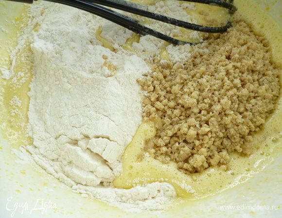Добавить растительное масло и опять взбить до однородности. Добавить просеянную муку с разрыхлителем, молотые орехи и опять хорошо перемешать.