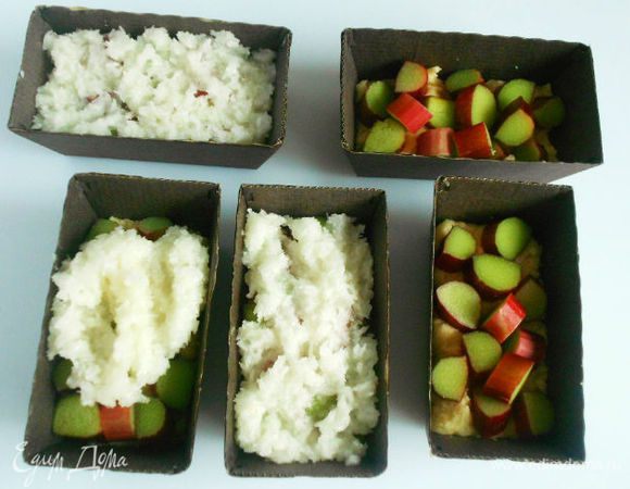  Если используете металлические формочки, то их нужно смазать маслом. Для силиконовых и картонных в этом нет необходимости.
Сначала каждую формочку наполовину заполнить тестом, затем выложить кусочки ревеня и сверху покрыть кокосовой массой.