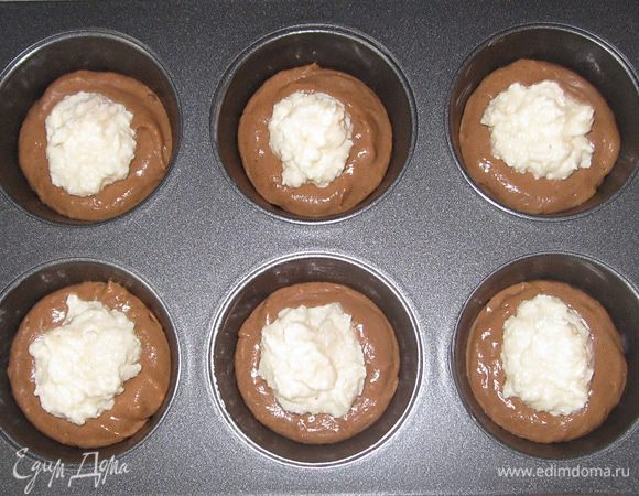 Форму смазать сливочным маслом. В каждую ячейку выложить 2 ч.л теста. В центр творог.