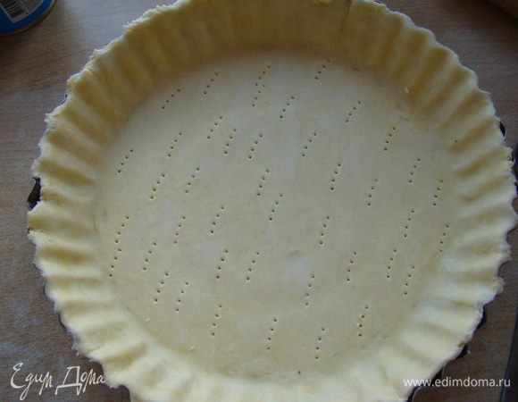 Раскатываем тесто, перекладываем в форму, накалываем вилкой, насыпаем сверху груз, выпекаем 10 минут