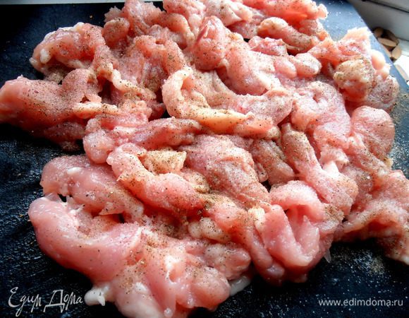 Кусочки курицы выложить на доску, посмотреть, какие надо подрезать, чтобы не было особо крупных... Затем обсыпать солью, перцем, перемешать руками.