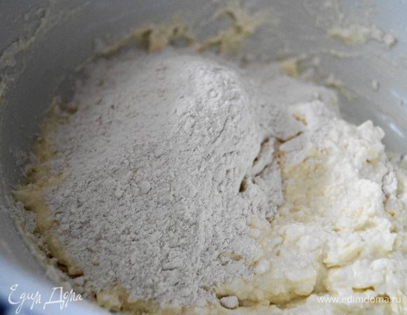 Всыпать постепенно всю муку, ее количество будет зависеть от влажности творога