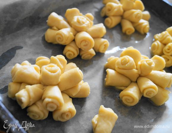 Доделываем из всего теста розы. И выкладываем их на противень застеленный бумагой для выпечки и смазанный немного маслом.