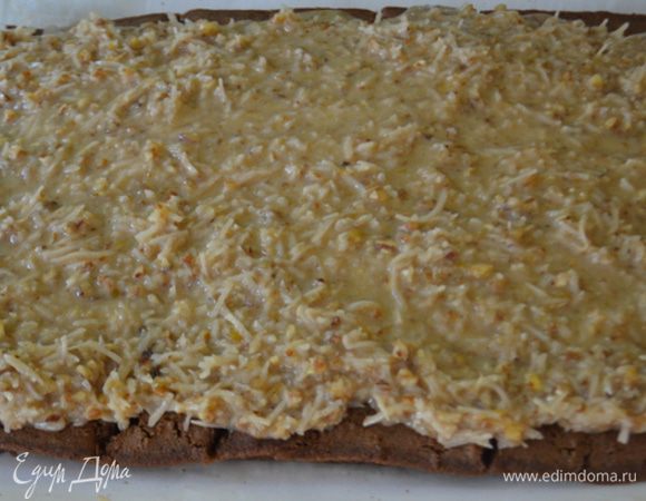 Затем развернем и выложим приготовленную кокосовую начинку с пеканом,распределяя по всей поверхности. Свернем в рулет и переложим в хлебную форму  вытягивая бумагу для выпечки осторожно.