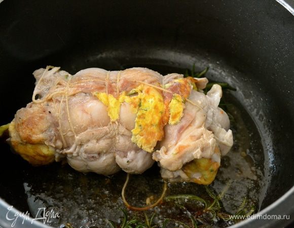 Поставить на огонь кастрюлю с тяжелым дном, которую можно затем поставить в духовку. Разогреть оливковое масло и положить обжариваться рулет. Добавить розмарин (шалфей) для аромата. Слегка обжарить кролика со всех сторон.   