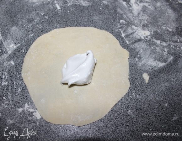 Достаем наши шарики из морозилки и раскатываем круг. На середину кладем чайную ложку нашего безе.