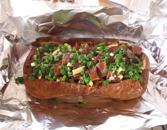 в чиабатту помещаем жаренные грибы.... плотно их вминая во все разрезы (помогаем пальцами). Нарезаем зеленый лук и перемешиваем его с 50 г растопленного сливочного масла.... поливаем этим соусом хлеб.... Заворачиваем в фольгу..... и ставим в духовку на 15 мин. 200 градусов...... Потом .... спустя 15 минут разворачиваем фольгу и снова поставим в духовку....на 15 минут.