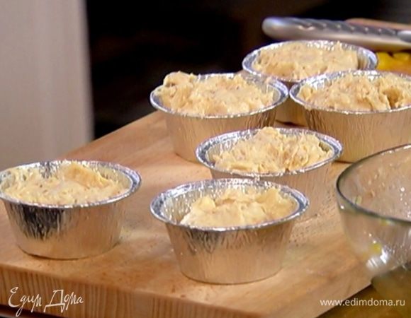 Формочки для маффинов смазать оливковым маслом, выложить на дно кусочки манго, затем заполнить формы тестом и отправить в разогретую духовку на 18 минут.