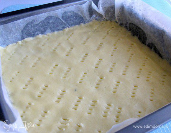Квадратный или прямоугольный противень с высокими бортами, смазать половиной масла, застелить пергаментом и смазать оставшимся маслом. Тесто преложить в противень, разровнять. Часто наколоть вилкой. 