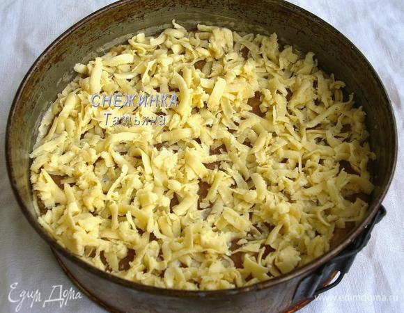 В форму на тесто выложите всю яблочную начинку. Сверху натрите на терке половину теста из морозилки.