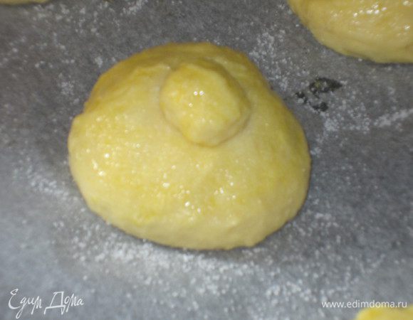 Сформировать круглые булочки. С оставшегося теста сформировать маленькие шарики и выложить на булочки.. Яйцо взбить венчиком. Булочки смазать яйцом и посыпать сахаром. Поставить на расстойку в тёплое место ещё на 30 минут.