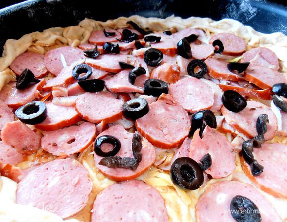 Ну ничего... С помощью четырёх рук и двух лопаток перемешаем драгоценный продукт в тефлоновую форму и на радостях благополучно присыпаем колбасками и оливками!