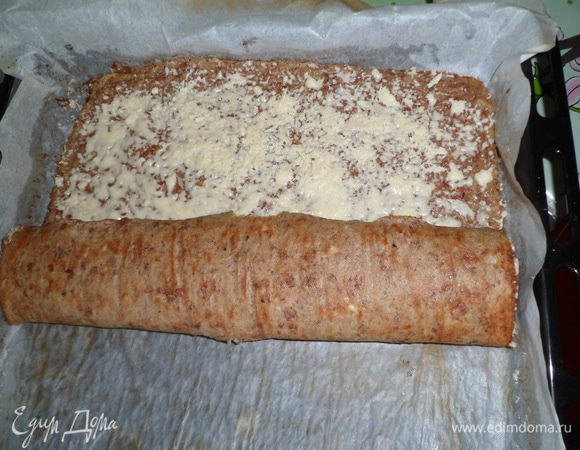 На горячий печёночный корж высыпать сыр, равномерно распределить по всей поверхности и свернуть в рулет и поставить в духовку еще на 5 минут.
