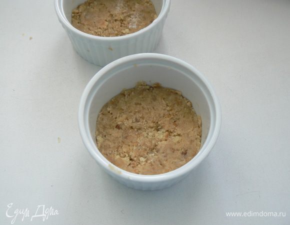 Смешайте крошку из печенья с маслом. Получившуюся смесь выложите в формочки, прижимая ко дну, чтобы получилась основа для чизкейка.

