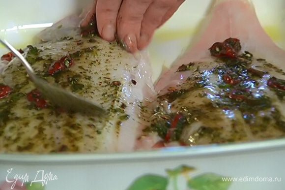 Керамическую форму для выпечки смазать оливковым маслом, выложить рыбу, обмазать со всех сторон пряной заправкой и дать постоять 10 минут.