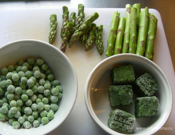 Пока ризотто печется, приготовим для него заправку. Берем нашу спаржу, шпинат и 100 г зеленого горошка. У спаржи отрезаем нежные верхушки.