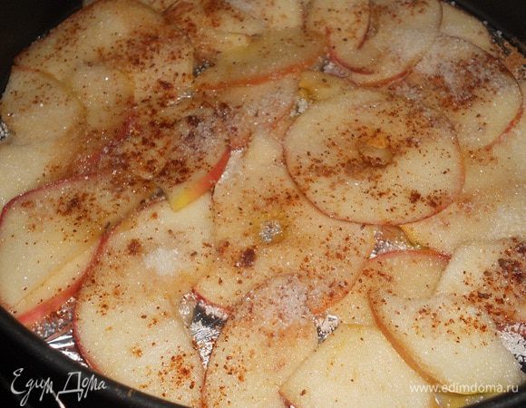 Уложить яблоки на дно формы, сверху посыпать ванильным сахаром и корицей.