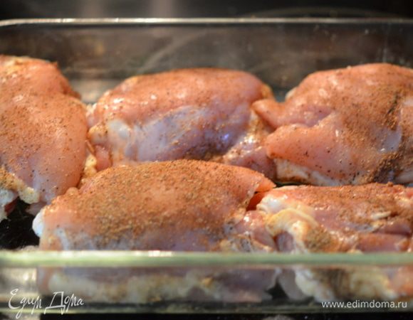 Посыпать смесью куриные бедра с обеих сторон. Выложить в жаропрочное блюдо или в глубокий противень.