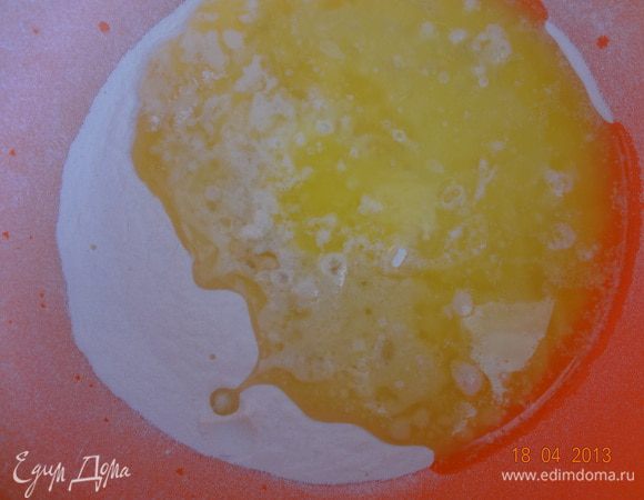 Муку просеять в другую миску, сделать углубление и влить оставшееся растопленное масло.