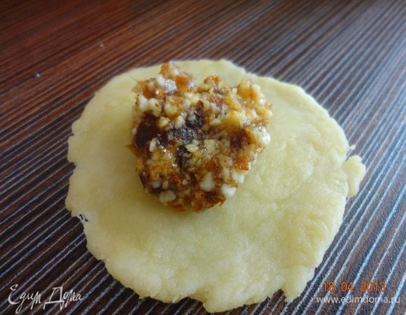 Отщипнуть от теста кусочек, размером с грецкий орех, скатать в шарик, затем раскатать скалкой в кружок (10-15 см.), на середину кружочка положить полчайной ложки начинки.