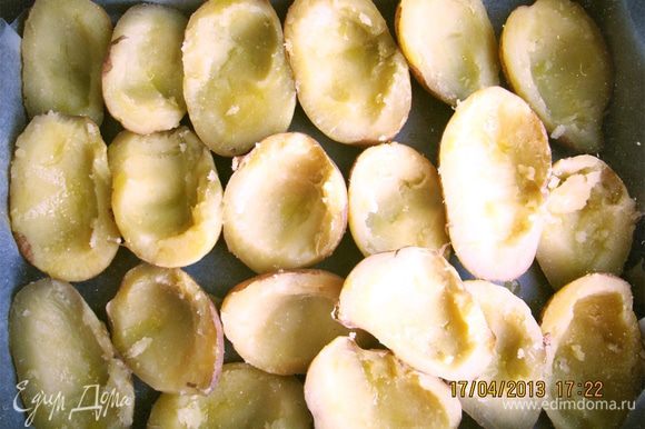 Разрезаем картофель вдоль на половинки и чайной ложкой делаем углубления (не больше косточки авокадо). Выстилаем противень пергаментом и складываем половинки, взбрызгиваем оливковым маслом.