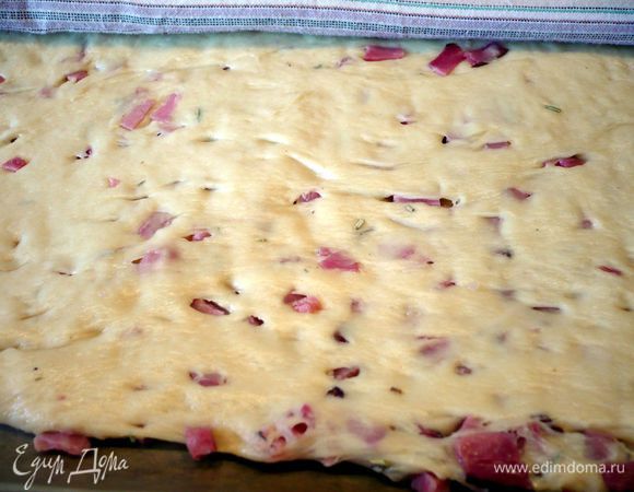 Тесто раскатываем в прямоугольник прямо на противне, покрытом пекарской бумагой до толщины примерно 1 см. Накрываем и оставляем подходить еще на 15 минут.
