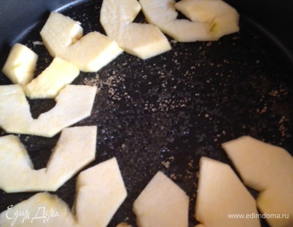 Берем любимую форму. У меня тефлоновая с высокими бортиками среднего диаметра. Смазываем её маслом и сверху щедро присыпаем коричневым сахаром (а вот и карамельная корочка!). Разрезаем яблоки на дольки (кубики - не самый удачный вариант, так как они могут не пропечься в серединке, а дольки будут очень мягкие и приятные) и укладываем ровным слоем.