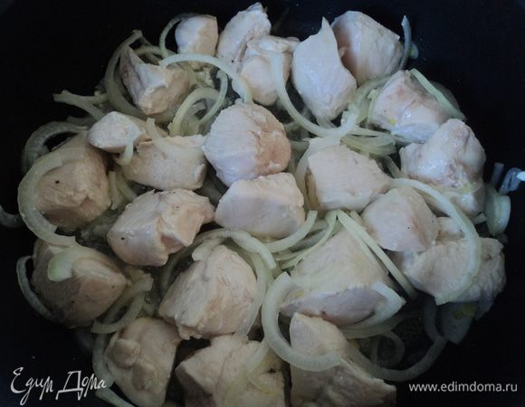 Добавляем лук к филе и перемешиваем. Накрываем сковороду крышкой, убавляем огонь и оставляем тушиться.