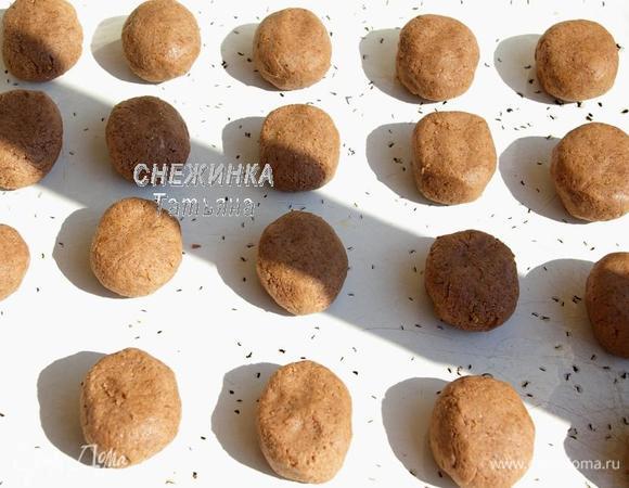 Из теста руками сформируйте шарики чуть больше грецкого ореха по величине и немного придавите их. Выложите на смазанный маслом противень.