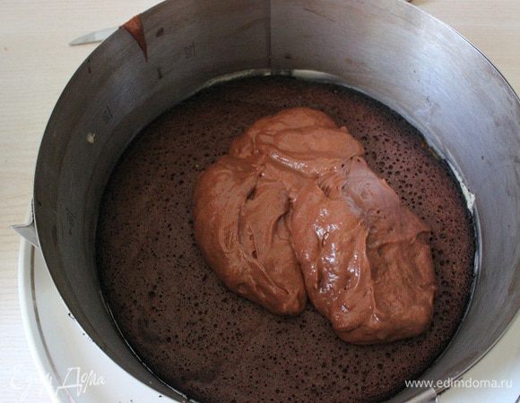 На дно формы размером 22 см выложить один шоколадный диск. По его поверхности распределить примерно 1/3 шоколадного мусса. Сверху выложить второй диск, слегка придавив его ладонью. Покрыть небольшим количеством мусса .