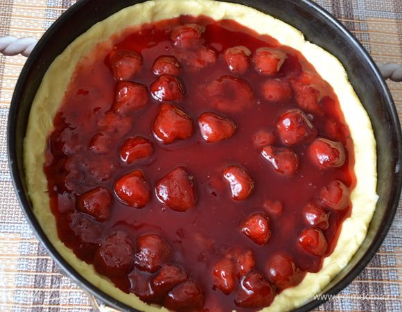 Из холодильника достать форму с основой. И распределить по ней начинку.