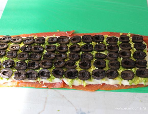 Оливки разрезать пополам и выложить их равномерно по всей поверхности