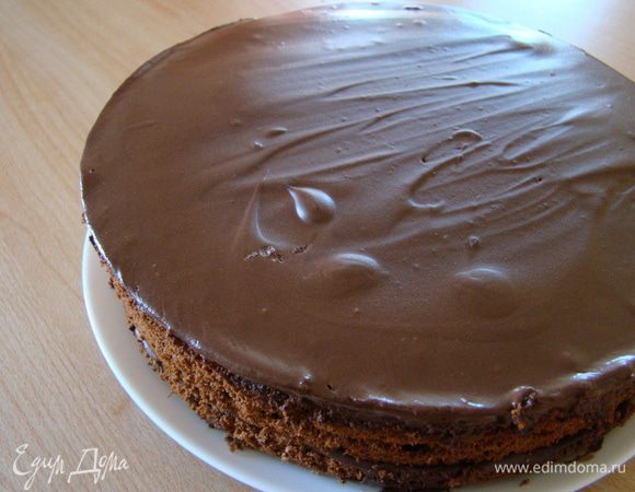 Второй корж также пропитываем сиропом и смазываем более жидким кремом-глазурью (1/2 порции + 1/4 порции густого шоколадного крема). Третий корж поливаем оставшимся кремом-глазурью, при неоюходимости одеваем тортовое кольцо, чтобы глазурь не убежала) и ставим в холодное место на ночь