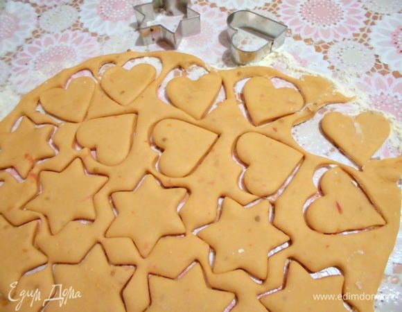Духовку разогреть до 180 градусов. Присыпать стол и скалку мукой. Отщипнуть часть теста и раскатать в тонкий пласт. Вырезать формочками печенье.