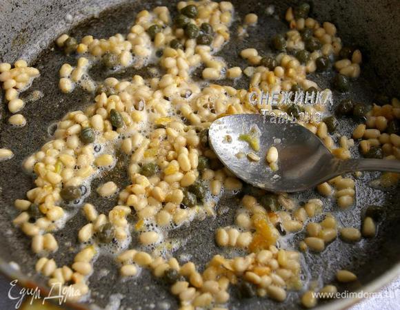 Пасту отвариваем в солёной воде до готовности аль денте, откидываем на дуршлаг, сохранив немного жидкости. На сковороде растапливаем сливочное масло, разминаем мягкий печёный чеснок, затем добавляем кедровые орешки и каперсы. Помешивая, жарим до золотистого цвета орехов.

