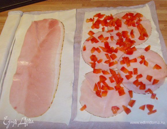 На полоски теста выложить пластинки ветчины, паприку мелко накрошить, распредилить по ветчине,