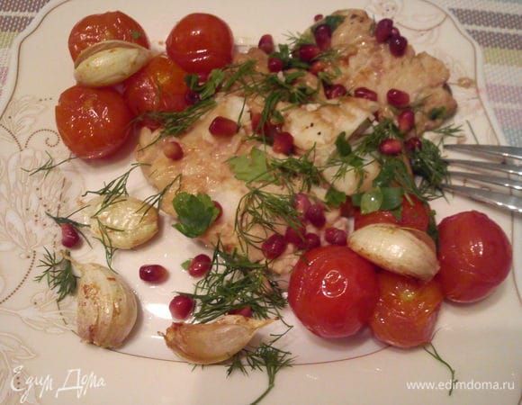 Выложить рыбку к помидорам и чесноку. Посыпать зернами граната и укропом.