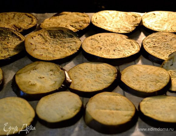 Тем временем на противень или на решетку от духовки (я предпочитаю решетку!) кладем бумагу для выпечки, и выкладываем на нее кружочки баклажана. Не надо ни соли, ни масла, ничего!.... Ставим в духовку примерно на 25 минут. По истечении половины указанного времени, переворачиваем все кружочки и заканчиваем запекать. У меня получается два противня... Как вариант, баклажаны можно приготовить в пароварке!!! Тоже получается очень хорошо! )) 