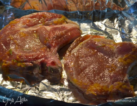 Используем бройл или духовку на 200 гр. Выстелим фольгу, затем выложим свиные отбивные. Смажем кисточкой свиные отбивные апельсиновой глазурью, добавим розмарин и поставим в духовку. Готовим до готовности мяса. Апельсиновые дольки за 10 мин. можно тоже выложить в духовку или отгрилить по желанию.