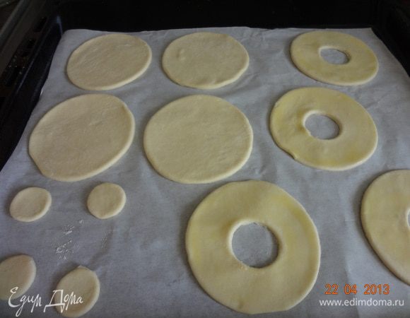 Поверхность колец смазать желтком, лучше тонкой кисточкой или пальцем, чтобы желток не попал на боковые поверхности. Выложить кружочки и колечки на противень (застеленный бумагой для выпечки), поставить в разогретую духовку, выпекать при температуре 230-250 С в течение 20-25 минут. Вынуть, полностью остудить на решетке.