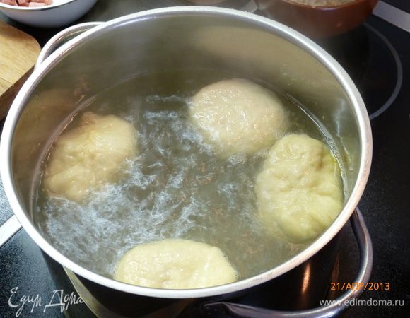 На плиту ставим большую кастрюлю с водой, доводим до кипения, в воду добавляем 2 ст.л. сахара и 1/4 стакана соды, вода должна активно забурлить. Опускаем в кипящую воду наши булочки на 30 сек., вылавливаем их шумовкой и выкладываем на противень, смазанный маслом.